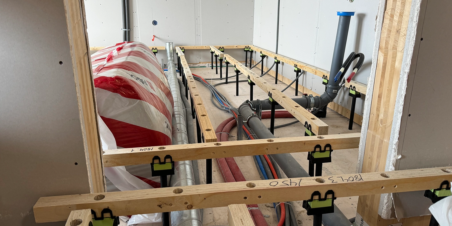 Granab verhoogde vloer op CLT constructievloer met ondervloersysteem voor installatieruimte
